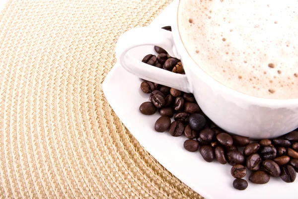 Cup of cappuccino coffee and beans — Stock Photo, Image