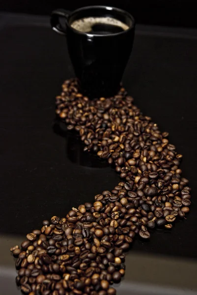 Bir fincan kahve ve dağınık fasulye — Stok fotoğraf