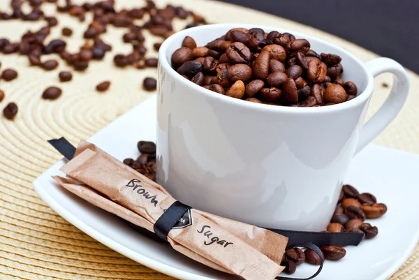 Кофейная чашка и бобы с коричневым сахаром — стоковое фото