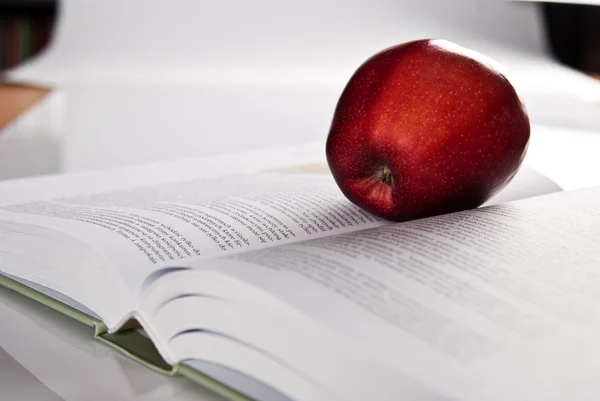 Open hefty book and fresh red apple — Stock Photo, Image
