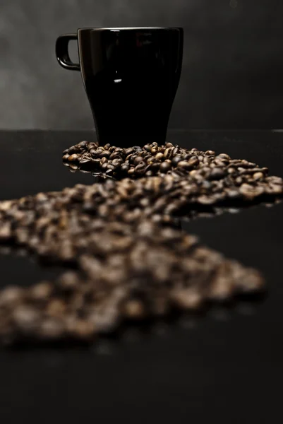 Mok van koffie en verspreide bonen — Stockfoto