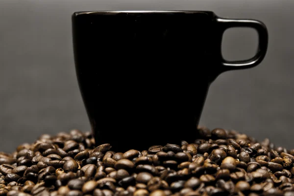 Чашка кофе и разбросанные бобы — стоковое фото