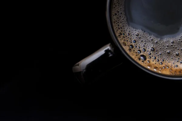Zwarte mok van koffie op zwarte achtergrond — Stockfoto