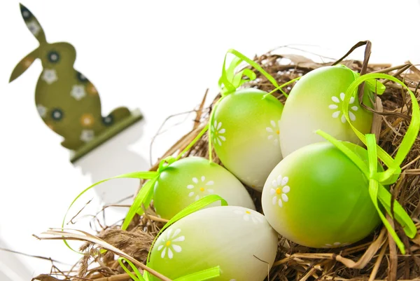 Пасхальные яйца в гнезде и кролике — стоковое фото