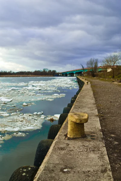 Konkreta kusten och isflak på floden — Stockfoto