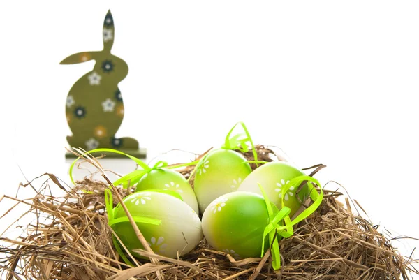 Пасхальные яйца в гнезде и кролике — стоковое фото