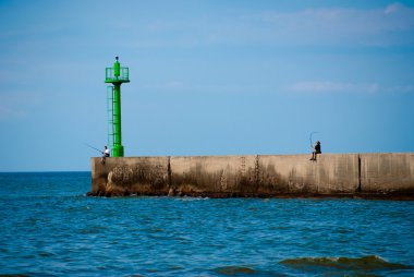 Two fishermans on the breakwater