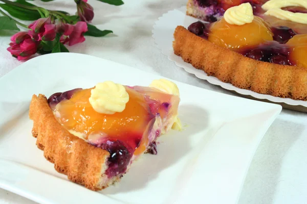 A piece of fruit cake and Alstroemeria — Stock Photo, Image