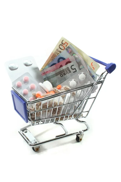 Carrinho de Compras com pílulas e dinheiro — Fotografia de Stock