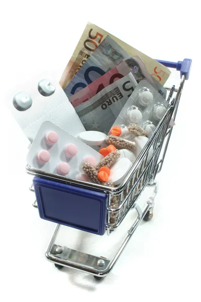 Carrinho de Compras com pílulas e dinheiro — Fotografia de Stock