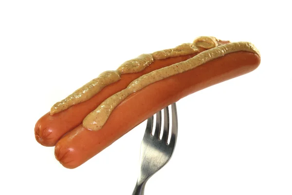 Wieners with mustard on a fork — Stock Photo, Image