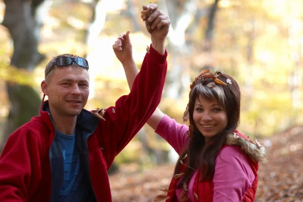 Mladý pár, kteří požívají padající listí — Stock fotografie