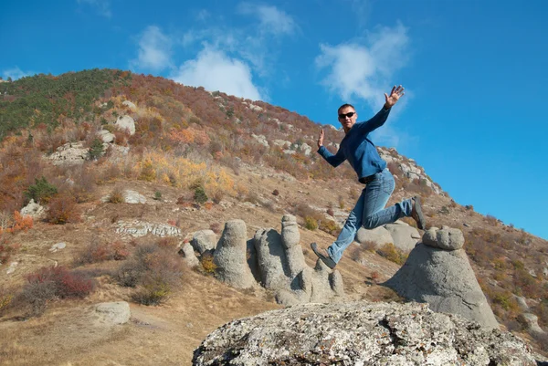 Человек, прыгающий на скалах — стоковое фото