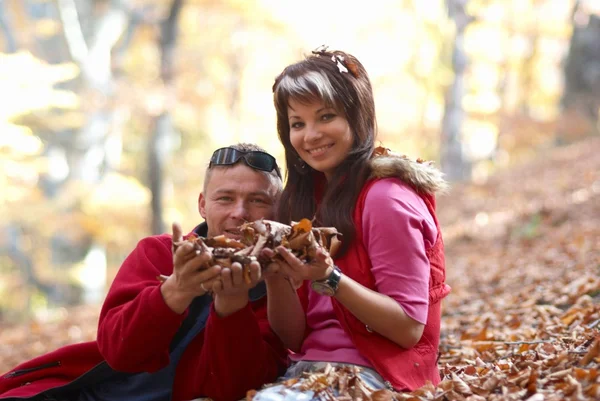 Jeune couple appréciant les feuilles tombantes — Photo