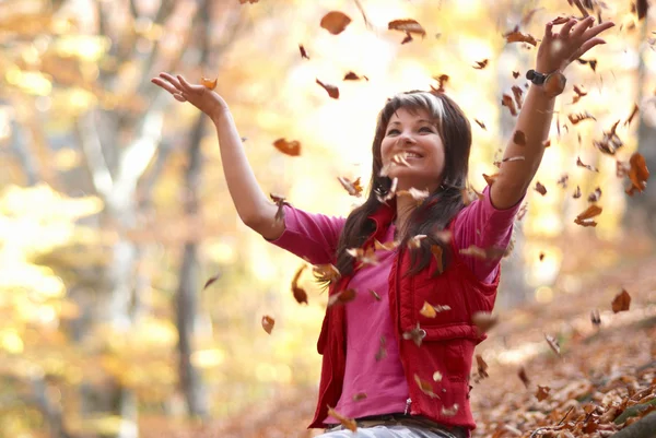 Красивая девушка с падающими листьями — стоковое фото