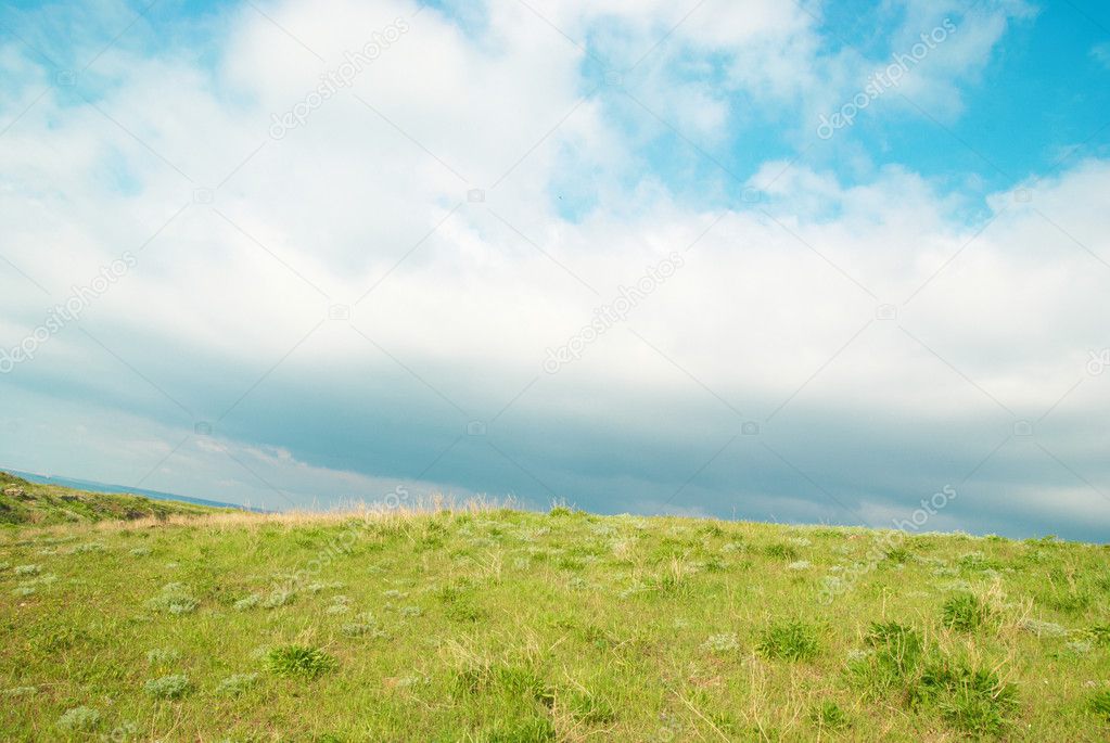Green landscape with clouds.