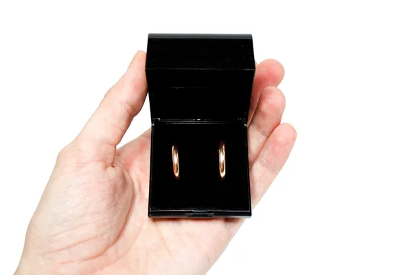 Zásnubní prsteny v černé skříňky v rukou — Stock fotografie