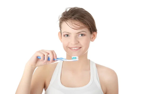 Chica joven cepillándose los dientes felizmente — Foto de Stock