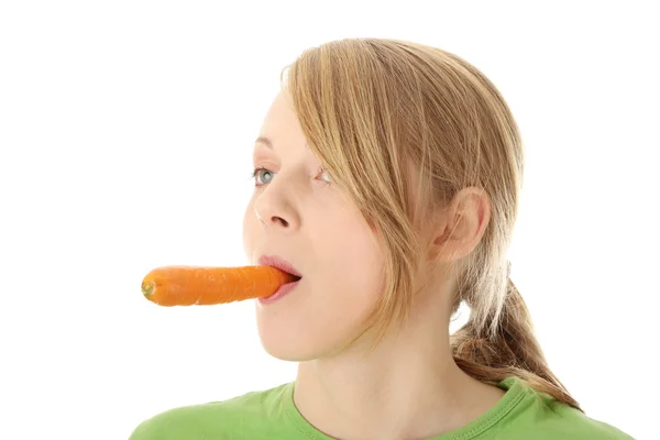 Mladá žena jíst mrkev — Stock fotografie