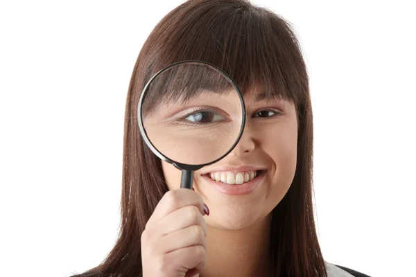 Woman looking into a magniying glass — Stock Photo, Image