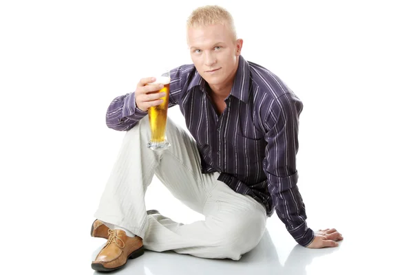 Onnellinen nuori mies, jolla on lasi olutta. — kuvapankkivalokuva