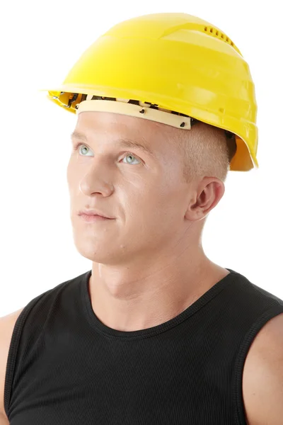 Молодой красивый строитель в желтом шлеме . — стоковое фото