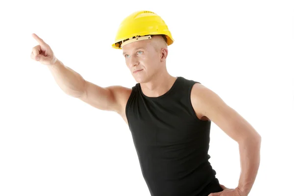 Construtor em capacete amarelo apontando para cima . — Fotografia de Stock