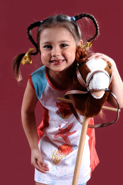 Het kleine leuk meisje met een stuk speelgoed — Stockfoto