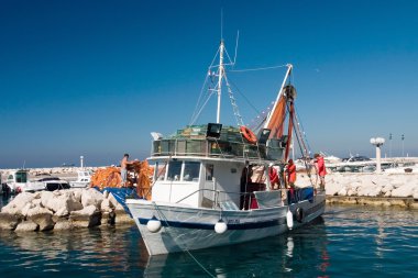 Fishermans prepare boat to sail out clipart