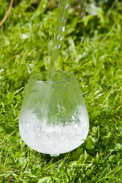 Pure water flows in a glass — Stock Photo, Image