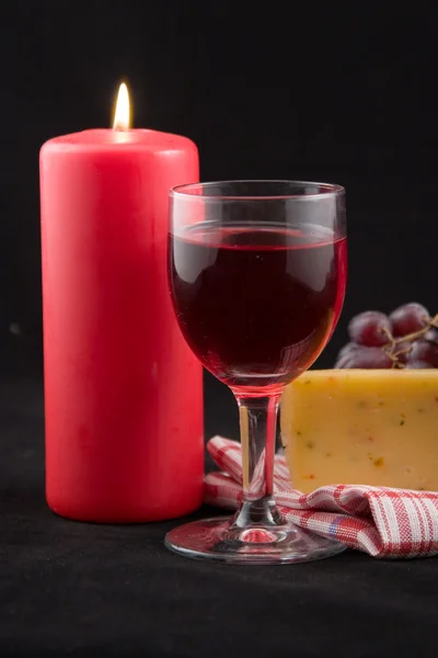 Víno a svíčku na černém pozadí — Stock fotografie