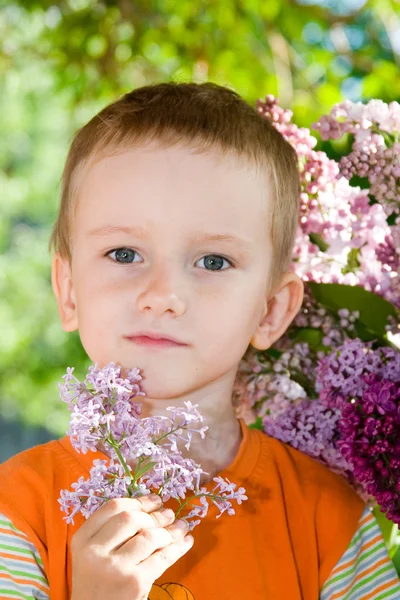 Boy with a bouquet of lilacs in the country — Stock Photo, Image