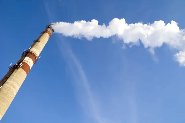 Pipe with smoke on blue sky — Stock Photo, Image