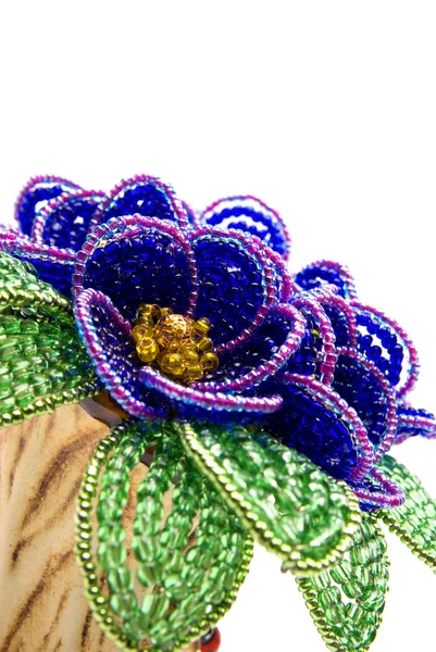 Blume aus blauen Perlen mit grünen Blättern — Stockfoto