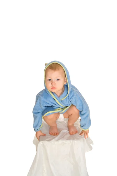 Baby in een badjas zit — Stockfoto