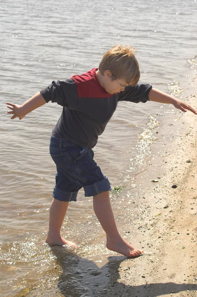 Хлопчик грає в океані — стокове фото