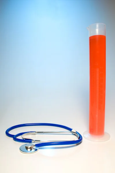 Stetoskop i cylinder pomiarowy — Zdjęcie stockowe