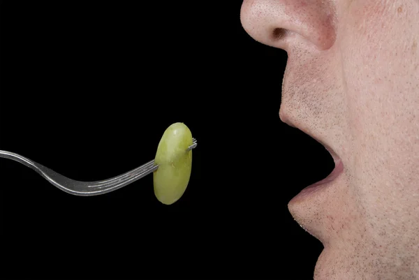 Homem comendo uma uva — Fotografia de Stock