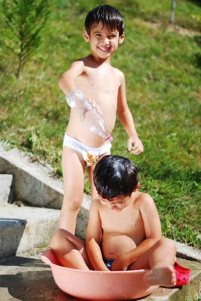 Su ile oynamak çok şirin çocuk üstün — Stok fotoğraf