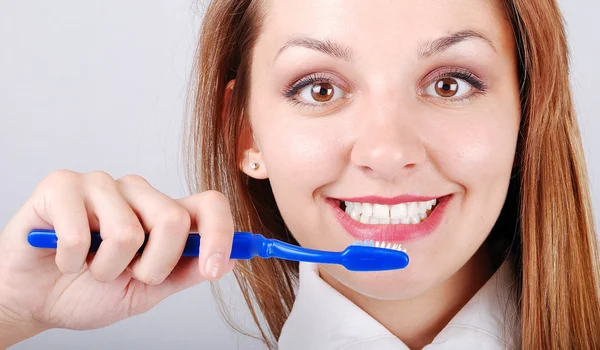Attractive female brushing teeth — Stok fotoğraf