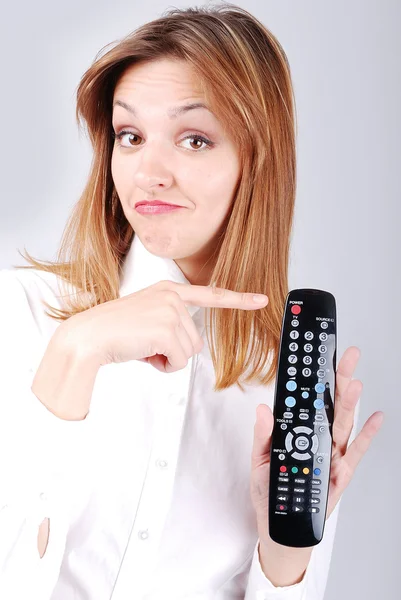 Attractive female pointing on remote control — Stock Photo, Image