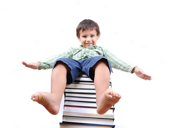 Little cute kid sitting on books tower — Stock Photo, Image