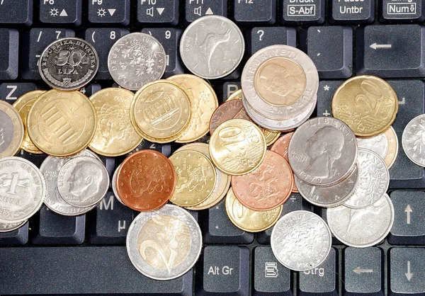 Monedas en el teclado —  Fotos de Stock