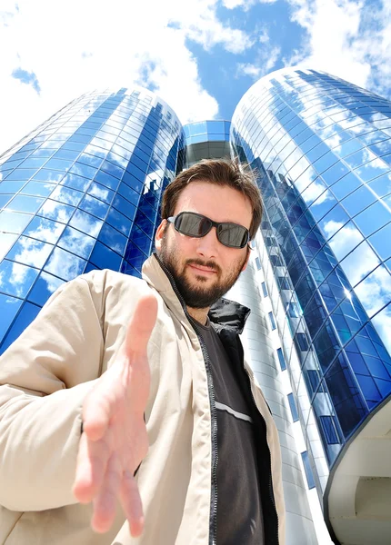 Young attractive man against blue glass — Stock Photo, Image