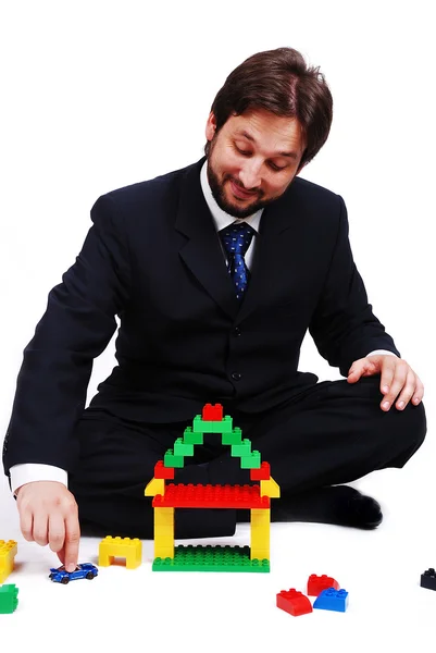 Young mane wearing suit is making a house with c — Stock Photo, Image
