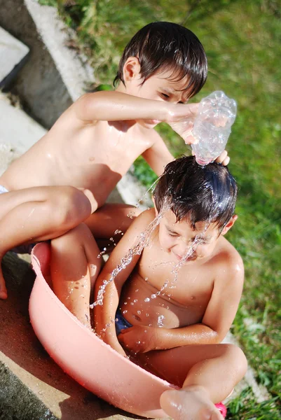 Bambino molto carino che gioca con acqua outdo — Foto Stock