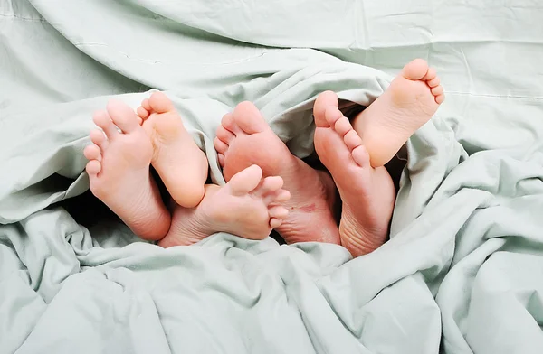 Boldog családi ágyban alatt lap — Stock Fotó