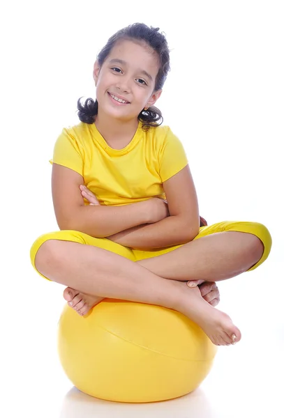 Mooi schattig meisje in gele kleren is — Stockfoto