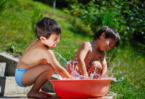 Muito bonito criança brincando com outdo água — Fotografia de Stock