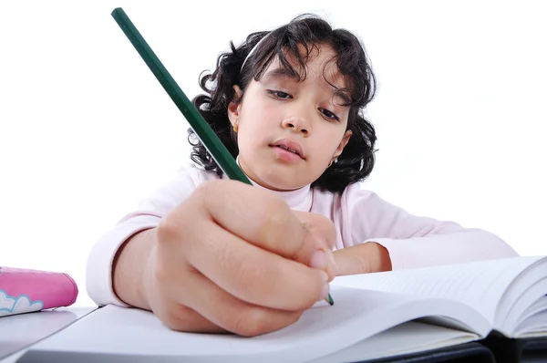 Маленькая симпатичная девочка пишет на блокноте — стоковое фото